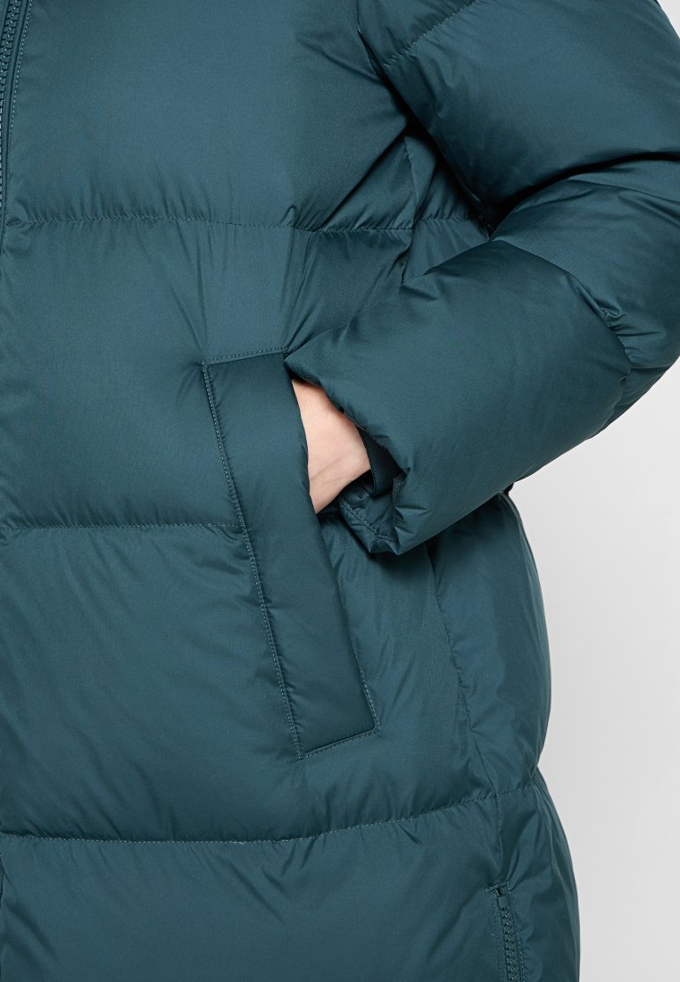 Teal farbene Daunenjacke mit strukturiertem Muster, ausgestattet mit einer Seitentasche und einem Reißverschluss. Das Material wirkt glatt und isoliert.