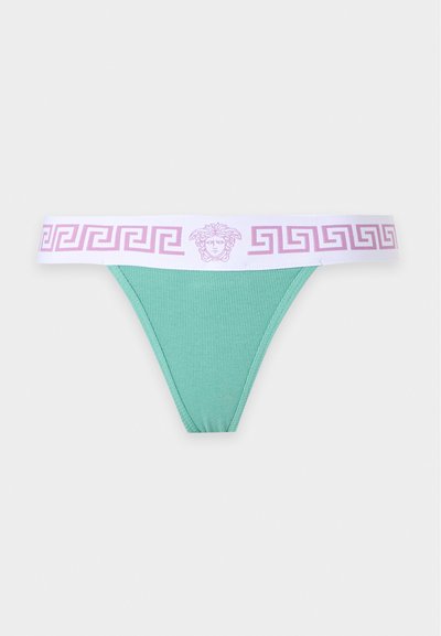 String côtelé vert avec une ceinture élastique blanche présentant des motifs clés grecques roses et un logo tête de Méduse au centre.