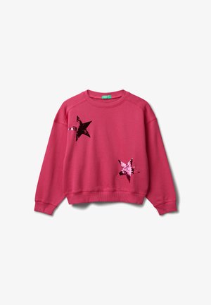 Różowy sweter z długim rękawem, z okrągłym dekoltem, z dwoma dużymi, błyszczącymi naszywkami w kształcie gwiazd pokrytymi cekinami z przodu.