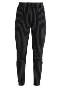 Schwarz gestreifte Hose mit einem verstellbaren Bund, taillierter Form und weichem Stoff. Vertikale weiße Streifen und Faltendetails sind sichtbar.