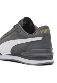 Graue und weiße Puma-Sneaker aus Wildleder und synthetischen Materialien, goldenes Puma-Logo an der Seite und der Ferse, gepolsterte Sohle, von der Rückseite betrachtet.