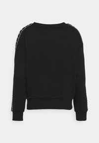 Sweat-shirt noir à manches longues avec poignets et ourlet côtelés, et détail de couture blanche en diagonale le long des épaules et des manches, vu de dos.