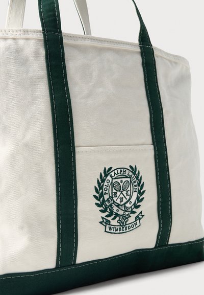 Sac fourre-tout en toile avec des poignées et des finitions vert foncé, arborant le logo Polo Ralph Lauren Wimbledon avec des raquettes de tennis et une couronne de laurier.