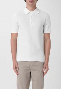 Polo shirt bianco a maniche corte in maglia, con colletto classico, pattina con tre bottoni, orlo a coste e un delicato motivo testurizzato.
