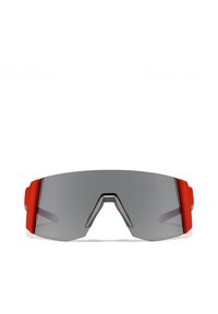 Napszemüveg nagy, sötétszürke lencsével, piros díszítéssel a kereten és jellegzetes, éles szögletes dizájnnal. Könnyű anyagból készült, modern formával.