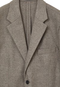 Blazer in lana marrone con revers, chiusura a un bottone e tasca applicata sul lato sinistro. Tessuto testurizzato con un motivo sottile.