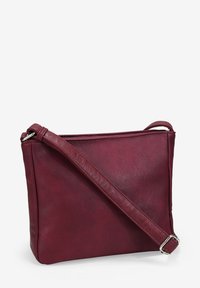 Bolso cruzado rectangular burdeos con correa ajustable y hebilla plateada, textura de cuero suave, sobre fondo blanco.