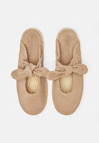 beige ruskinds slip-on sko med en rund tå, knyttet frontrem og flettet juta såldetalje. Glat tekstur og minimalistsk design.