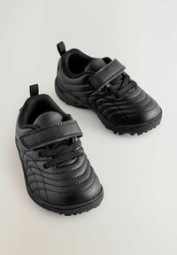 Zwarte sportieve schoenen van textuur synthetisch materiaal, met een klittenbandsluiting, veters en rubberen zolen voor grip.