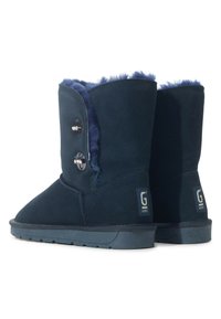 Botines de ante azul marino con forro de piel sintética, dos botones decorativos en el lateral y suelas de goma texturizada para un buen agarre.