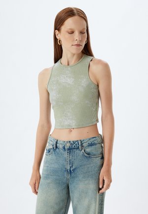 Top corto a coste verde chiaro con scollatura rotonda e design senza maniche. Presenta una leggera lucentezza e una silhouette aderente.