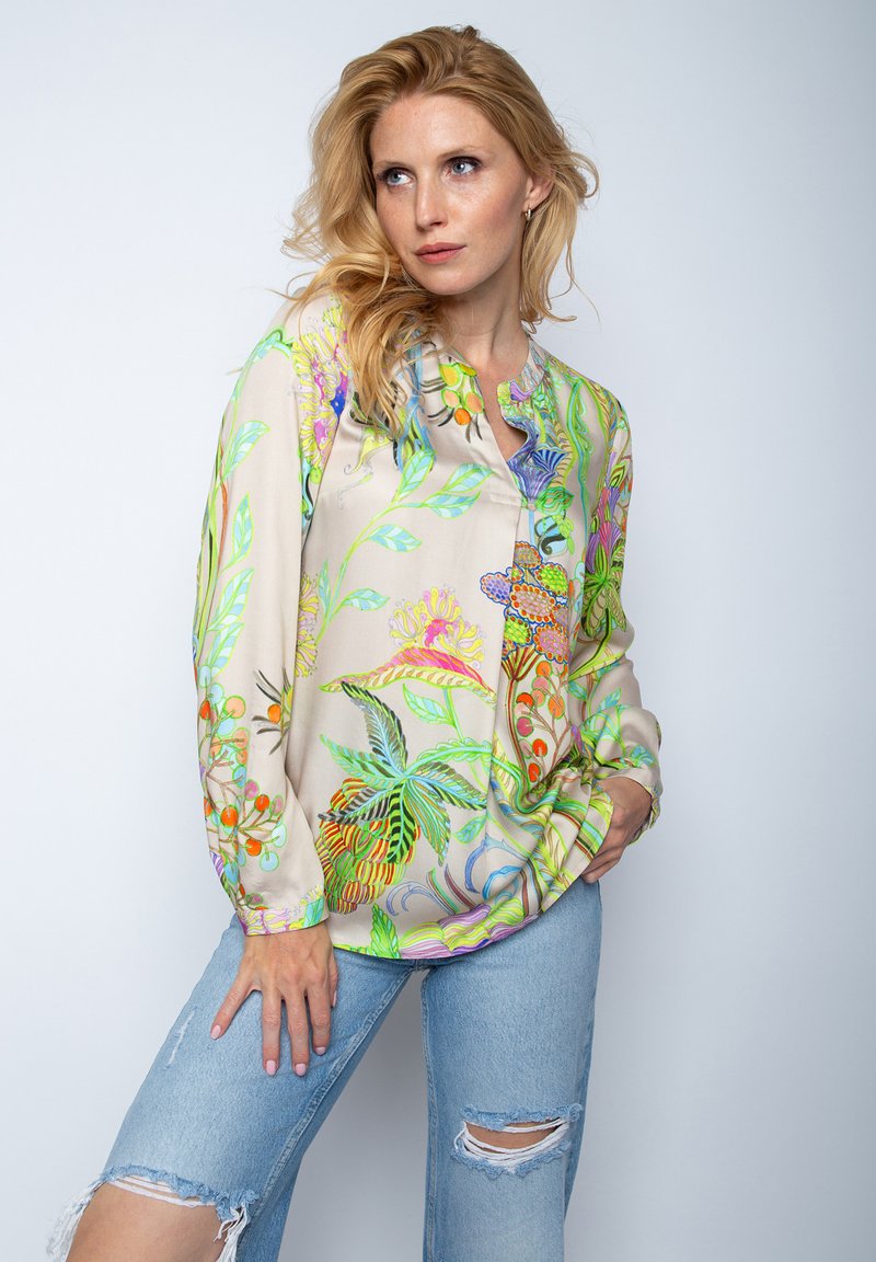 Lichte blouse met lange mouwen in beige, versierd met levendige botanische prints in groen, roze en blauw; heeft een ronde halslijn en een losse pasvorm.