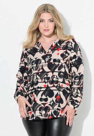 Long-sleeve blouse with a V-neck, featuring a beige fabric with black and red heart and diamond patterns. Lightweight, relaxed fit.