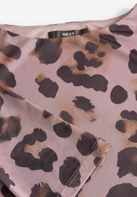 Látka s leopardím potiskem v odstínech růžové a hnědé s hladkým povrchem. Má zaoblený výstřih a viditelné stehování podél lemu.