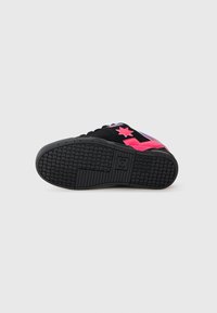 Black skate shoes with pink accents, textured rubber outsole, and star logo detail. Features a smooth upper with laces and reinforced toe cap.