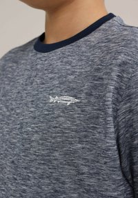 Marinblå och gråmelerad t-shirt med rund halsringning och korta ärmar. Har en liten vit fiskbroderi på bröstet. Mjuk textur.