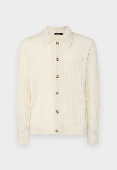 Cream ribbed knit cardigan with a button-up front, spread collar, and five round buttons, featuring a textured fabric and fitted cuffs.