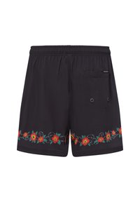 Zwarte zwembroek van gladde stof, voorzien van levendige rode en groene bloemendecoraties langs de zoom, en een achterzak met oogjes.