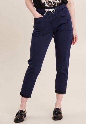 Marineblaue Hose mit elastischem Bund und weißem Kordelzug. Mit zwei Vordertaschen und hochgekrempelten Säumen. Aus leichtem Material gefertigt.