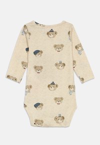 Svijetlosmeđi bodysuit dugih rukava s ponavljajućim uzorkom ilustriranih medvjedića u raznim šeširima i dodacima. Mekana, strukturirana tkanina.