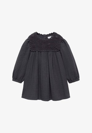 Robe noire à manches longues avec taille froncée, empiècement floral en crochet, poignets élastiques et encolure ronde.