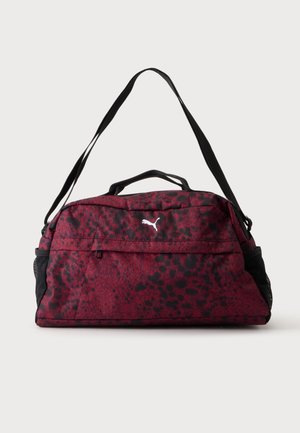 Borsa sportiva rossa e nera a pois con tasca frontale con cerniera, tasche laterali in rete nera, doppi manici e tracolla regolabile.