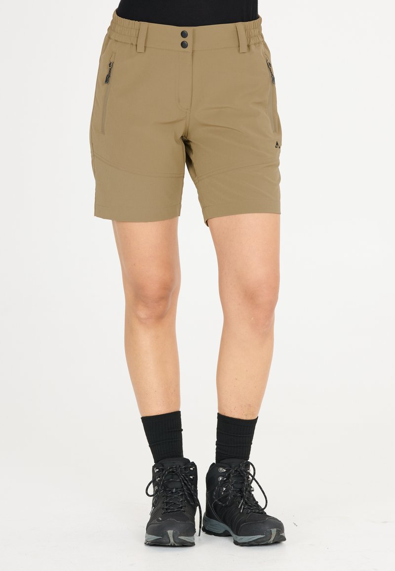 Khaki shorts dengan pinggang elastis, dua kantong samping berzip, dan tekstur yang halus. Dipadukan dengan sepatu hiking hitam dan kaus kaki.