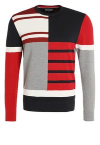 Pull en tricot avec col rond, arborant un motif géométrique composé de rayures rouges, bleu marine, grises et blanches sur le devant et les manches.