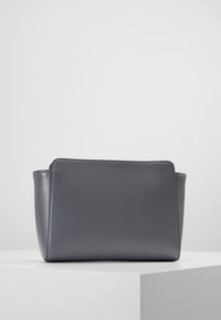 Szara skórzana torebka o prostokątnym kształcie, teksturowanej powierzchni i subtelnym przeszyciu wzdłuż górnej krawędzi. Brak widocznego sprzętu ani wzorów.