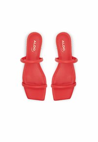 Röda slidesandaletter med en slät ovandel, dubbla remmar, fyrkantig tå och platt sula. Märkningen synlig på innersulan.
