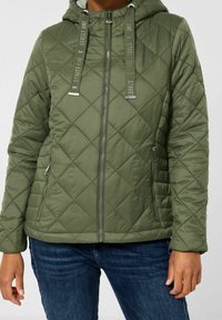 Vihreä tikattu takki hupulla, jossa vetoketjullinen etuosa, tekstiiliset kiristysnauhat ja sivutaskut. Materiaali näyttää sileältä ja kevyeltä.