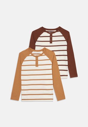 Kaksi pitkähihaista paitaa raglanhihoilla. Toinen on vaaleanbeige- ja ruskearaitainen; toinen on yksivärinen ruskea, jossa on vaaleanbeige raidoitus. Molemmissa on napit.