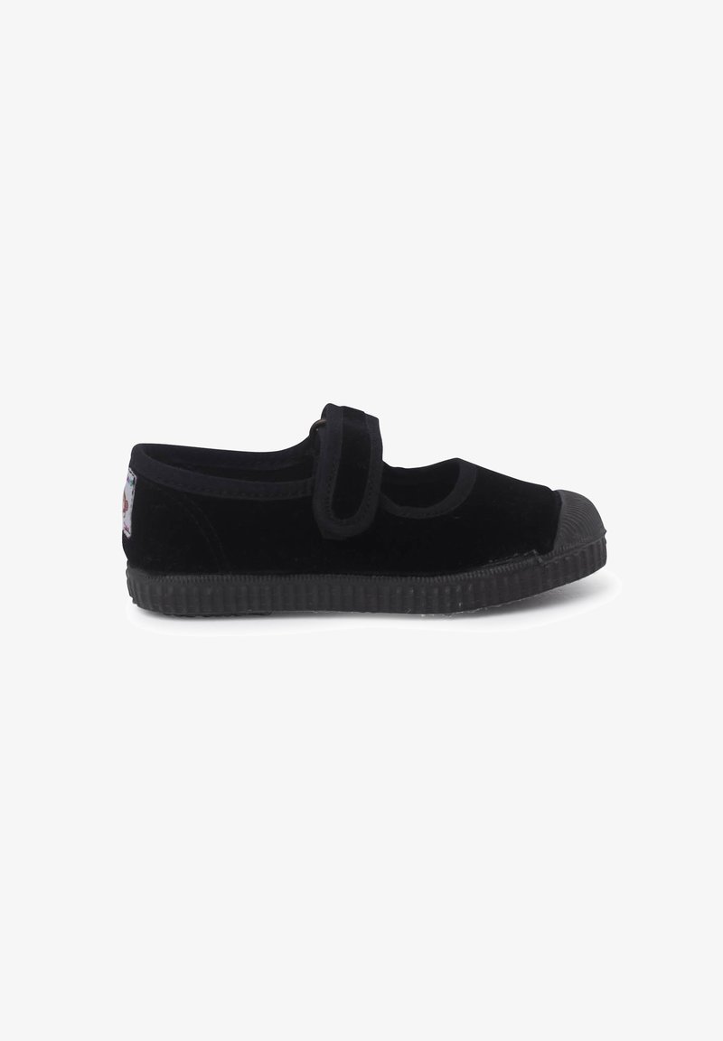 Zapato negro de terciopelo estilo Mary Jane con correa, suela de goma y punta redondeada. Presenta una superficie texturizada y una suela negra contrastante.