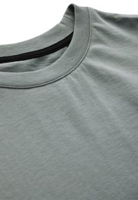 Světle zelené tričko s kulatým výstřihem, vyrobené z jemné bavlněné tkaniny. Má ribbovaný límec a mírně strukturovaný povrch.