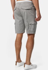 Graue Cargo-Shorts mit lockerem Sitz, mehreren Taschen, einer glatten Vorderseite und einem elastischen Bund. Strukturierter Baumwollstoff.