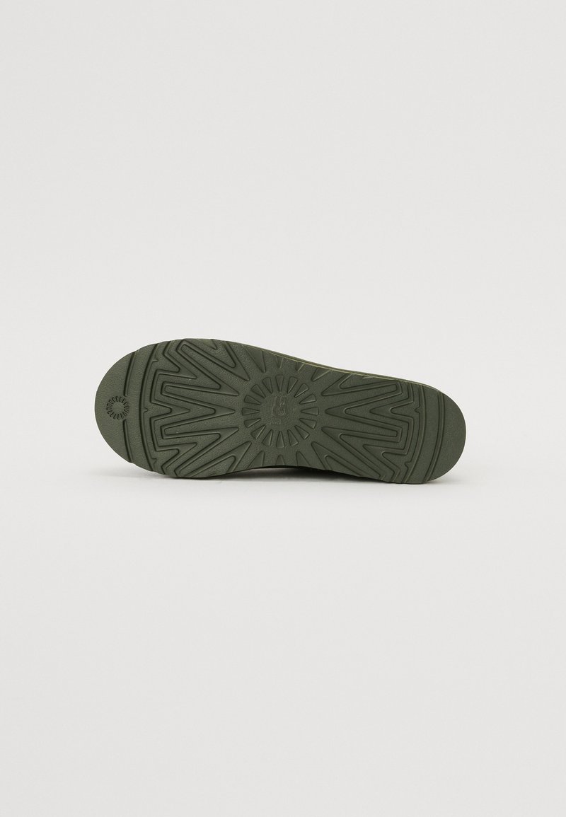 Groene rubberen zool met een patroon van zigzag- en cirkelelementen, een gladde textuur en een ronde neus.