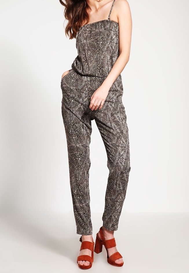 Jumpsuit a fantasia nera e marrone con spalline sottili, gambe affusolate e vita elastica. Indossato con sandali marroni con tacco a blocco.