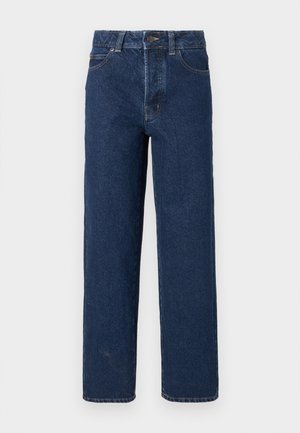 Σκούρα μπλε τζιν με ίσια γραμμή, τσέπες μπροστά, θηλάκια για ζώνη, κούμπωμα με κουμπί και εμφανείς ραφές, σε λευκό φόντο.