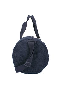 Sac de sport en polaire bleu marine, rond, avec une bandoulière noire réglable et des poignées sur le dessus, sur fond blanc.