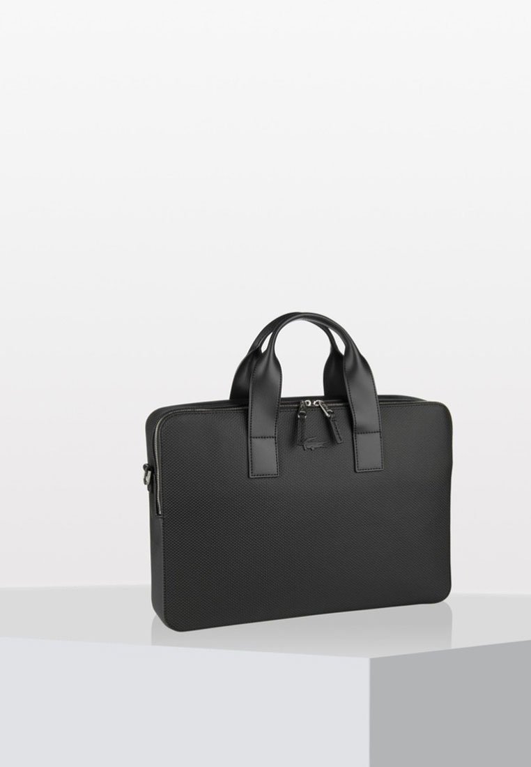 Geantă de laptop texturată neagră, cu două mânere superioare, închidere cu fermoar și un accent mic sub formă de charm. Prezintă o formă rectangulară elegantă.