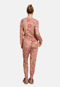 Rosa Schlafanzugset mit floralem Muster, langen Ärmeln und eng zulaufenden Hosen, ausgestattet mit lebendigerstickerei. Weicher, kuscheliger Stoff und elastischer Bund.