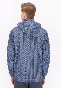 Jachetă cu glugă din material albastru, cu un model floral geometric. Prezintă mansete elastice și un tiv drept, concepută pentru o potrivire lejeră.