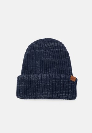 Marineblaue Strickmütze mit gerippter Textur und umgeschlagenem Rand. Verfügt über ein kleines braunes Lederetikett an der Seite.