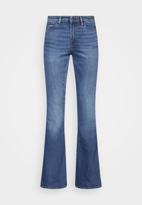 Jeans de tiro alto y pierna acampanada en denim azul medio, con textura suave, desvanecido sutil y diseño estándar de cinco bolsillos con botón de metal.