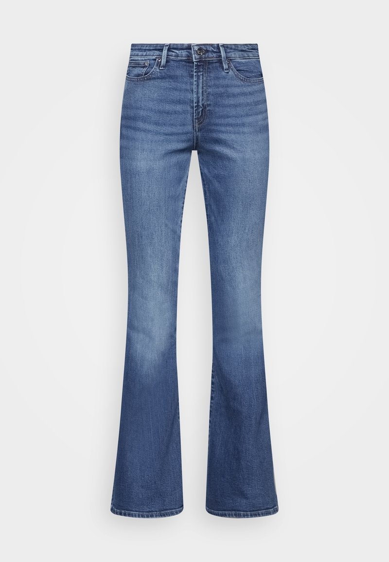Jeans de tiro alto y pierna acampanada en denim azul medio, con textura suave, desvanecido sutil y diseño estándar de cinco bolsillos con botón de metal.