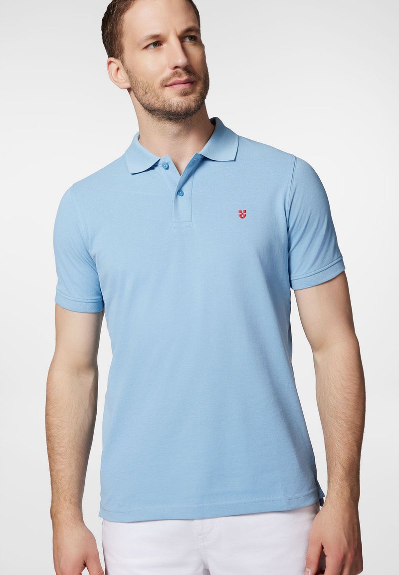Jasnoniebieska koszulka polo wykonana z bawełny, z trzyguzikowym zapięciem, krótkimi rękawami i małym czerwonym emblematem na lewym piersi.