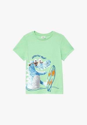 Zelena pamučna majica s plavim dinosaurom u šljokicama koji drži surf dasku, s natpisom "HOPNI NA VAL!" u plavoj boji iznad grafike.