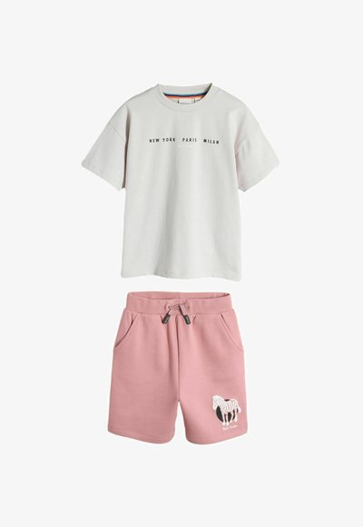 Hvid T-shirt med korte ærmer med teksten "New York Paris Milan" og pink shorts med snøre samt et zebragrafik på venstre ben.