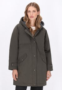 Mørkegrøn parka med hætte, udstyret med trykknapper, to frontlommer og en kontrasterende grå indvendig foring. Glat, vandafvisende stof.