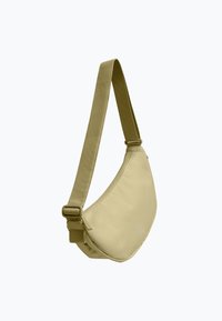 Bolso de bandolera caqui hecho de tela suave, forma redondeada, correa ajustable y herrajes laterales para un cierre seguro. Diseño minimalista.